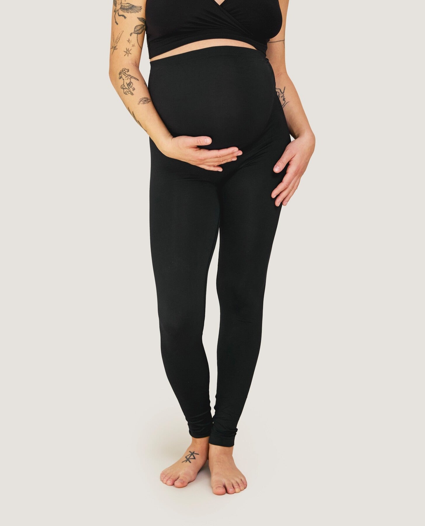 Gravid kvinde iført sorte Carriwell sømløse leggings med støttepanel over maven